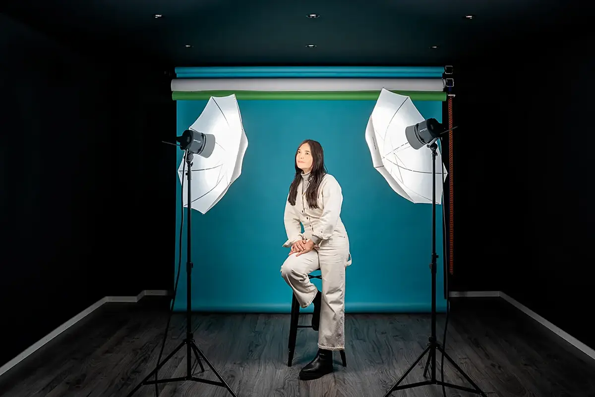 Cornland Studio - Femme sur un tabouret lors d'un shooting dans un studio d'enregistrement vidéo avec fonds de couleurs