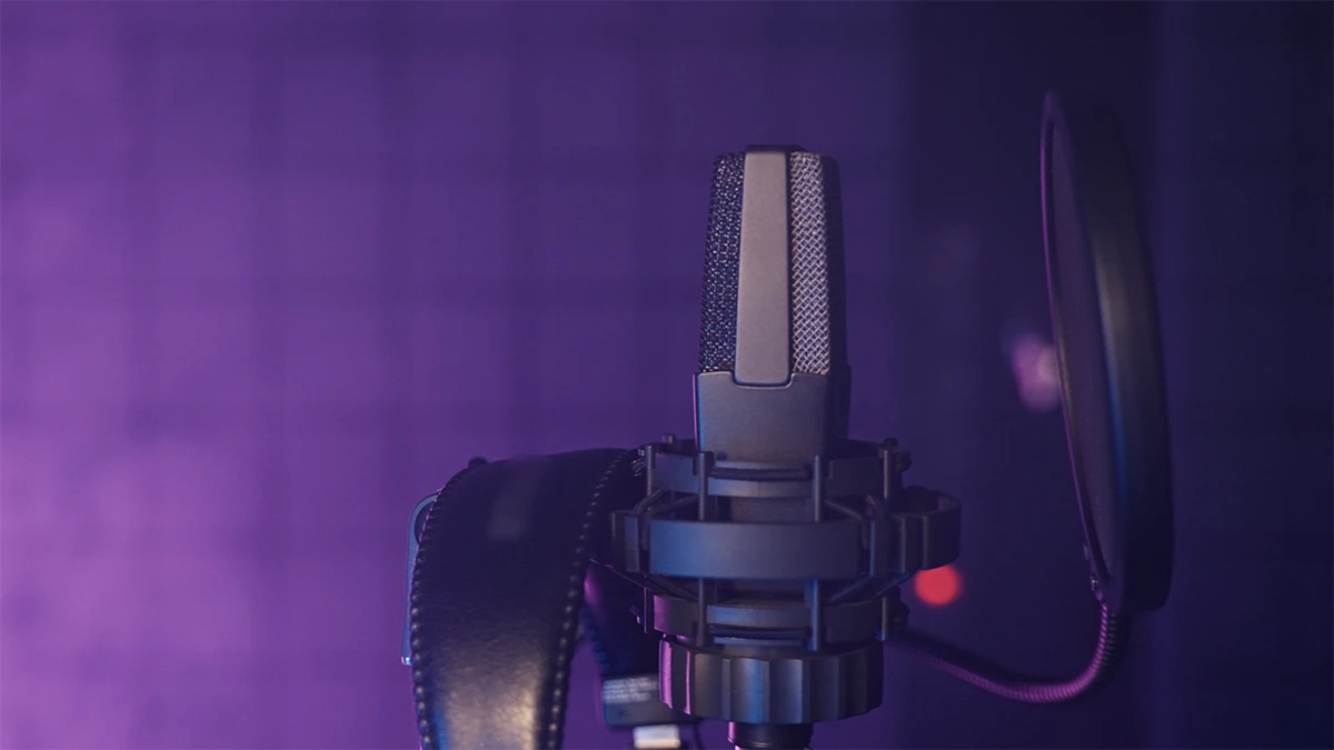 Cornland Studio - Gros plan d'un micro dans un studio éclairé par des lumières violettes